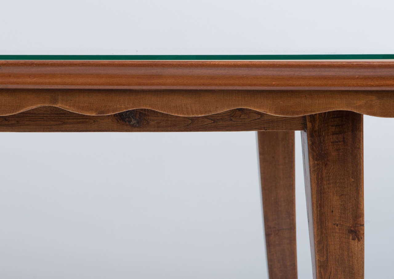 A walnut dining table in the style of Paolo Buffa.
Walnut top with solid walnut moulding above a waved apron, tapering feet.
Glass top is modern.
Italy, circa 1940.
160 cms w x 80 cms d x 80 cms h.