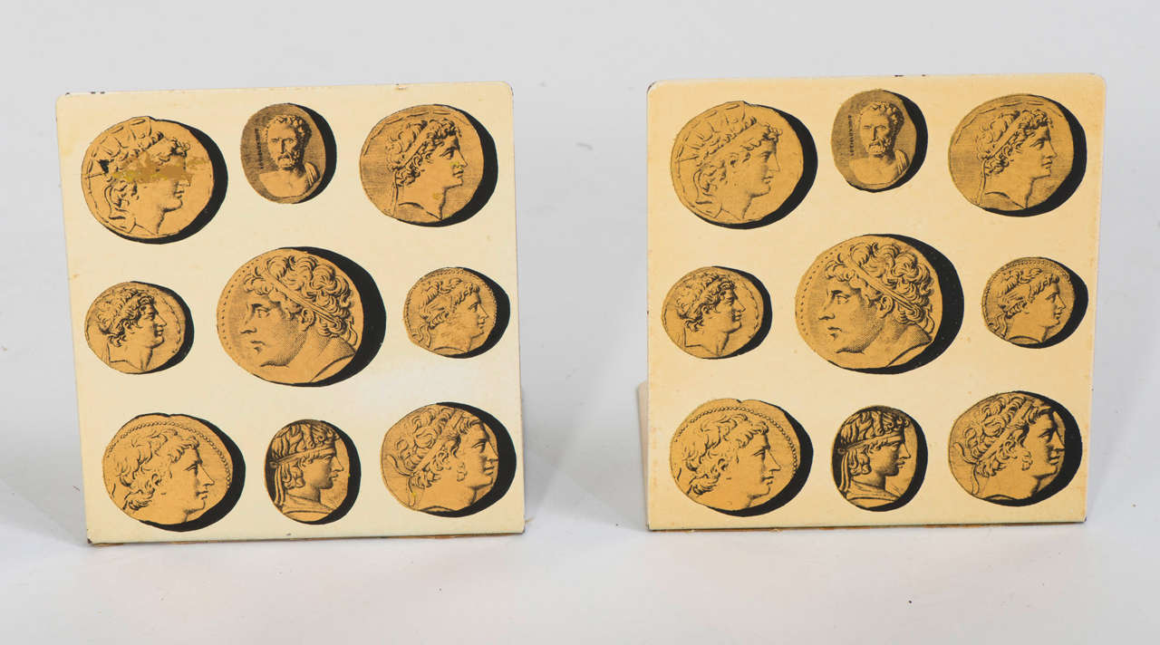 Pair of “Cammei” Bookends by Piero Fornasetti.
Depicting gold medallions against a cream ground.
Metal, lithographically printed with gilt highlights.
Signed to base.
Italy, circa 1950.
15 cms h x 13.5 cms w x 10 cms d.