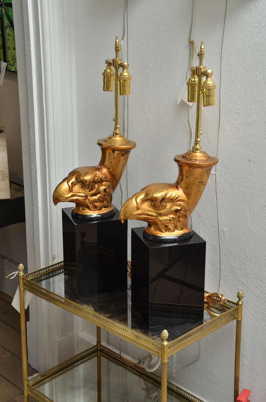 Pair of gilded eagle head lamps mounted on black Lucite bases.