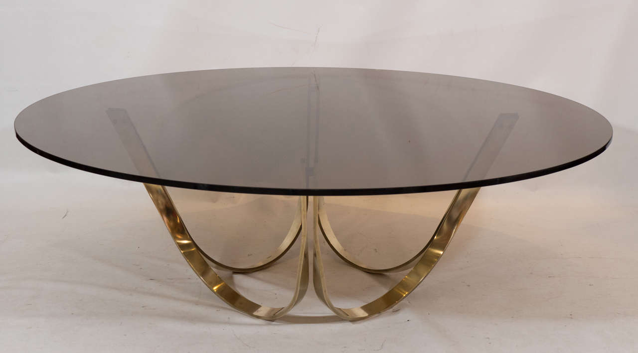 A beautiful sculptural brass base supports a top of gorgeous dark bronze tinted glass. Please contact for location.