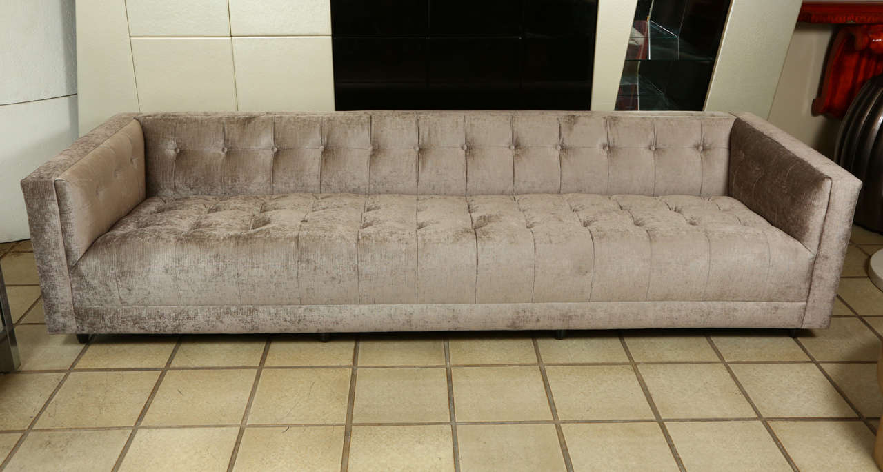 This glamorous biscuit tufted sofa has crisp lines, and has been newly reupholstered in a silvery gray chenille fabric.