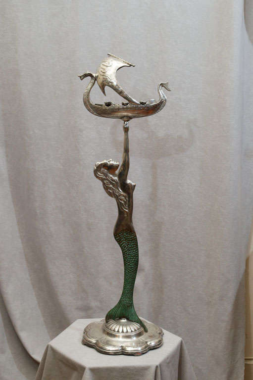 For the man's den, this one's going to be tough to beat.  This very special and unique ashtray is made of bronze and has all the bells and whistles.  The mermaid holds the ship with the removable insert ashtray.  All is nickel plated with green