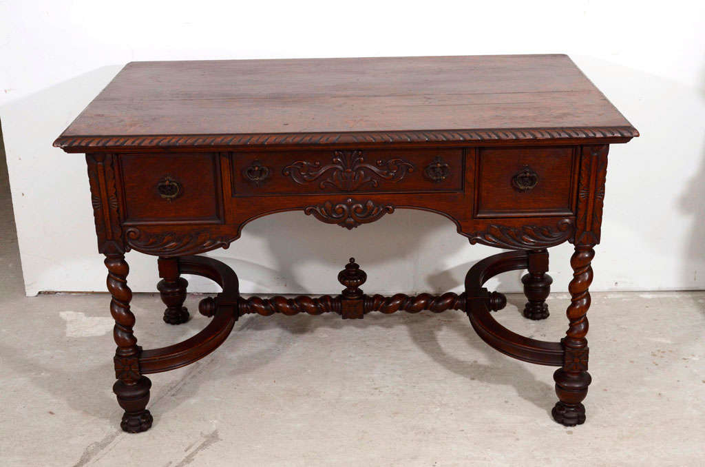 A beautiful Louis XIV oak desk hand crafted with four turned legs,  cross stretcher at the bottom and three drawers with the original hardware and original patina.