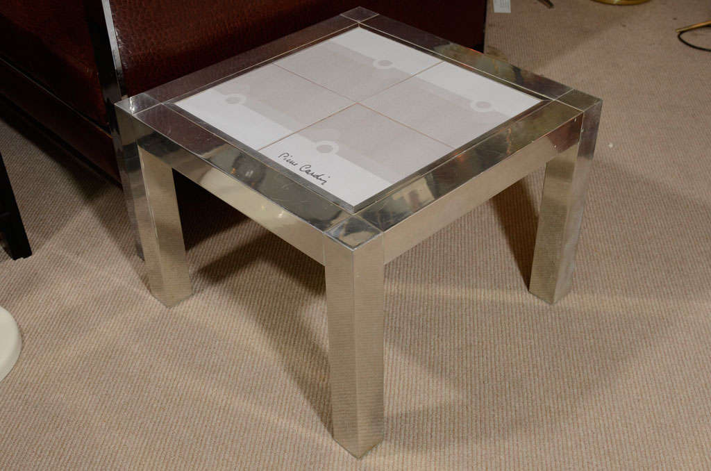 A rare Pierre Cardin end table in chrome with ceramic tile top, circa 1970. Four tiles in three shades of light grey create an abstract design. One tile signed 