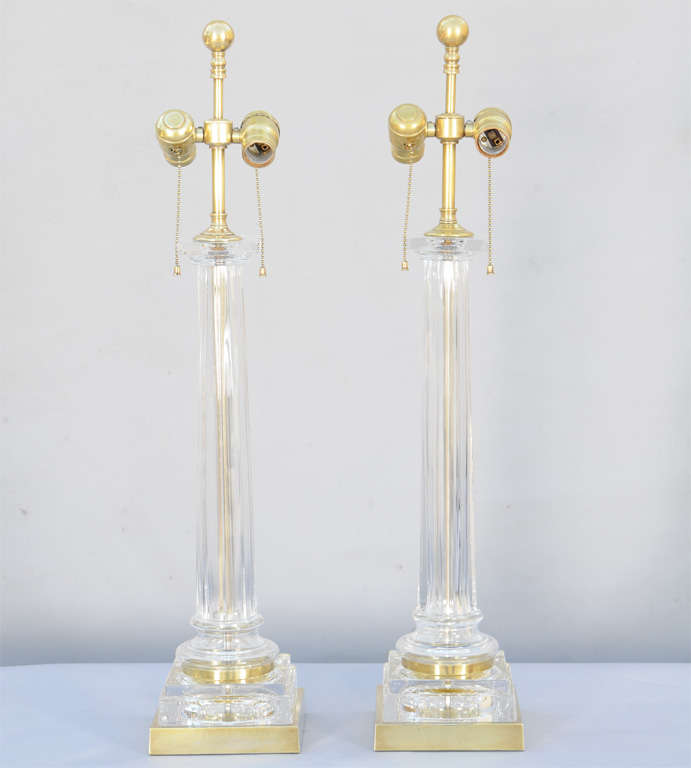 Pair of table lamps by Paul Hanson, each a square-edged column of glass, on round foot and graduated plinth on brass base.