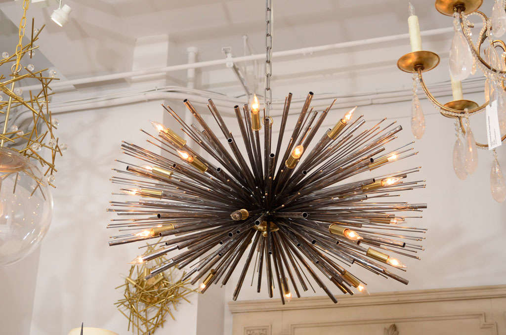Description: An original sculptured metal sculpture by Lou Blass, acclaimed for his sculptures, fountains and installations, creates custom lighting and furniture in his design
studio. His “Supernova” chandelier [shown in steel with bronze accents,