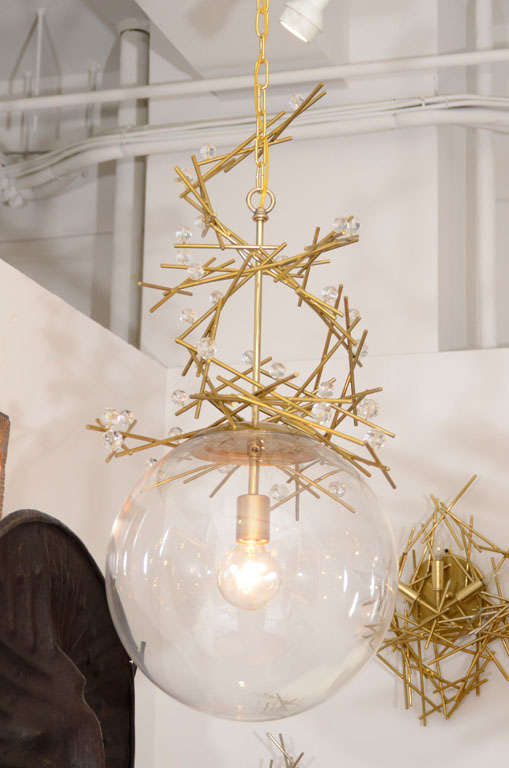 A 14" acrylic ball with powder-coated buttered brass and crystal light fixture.