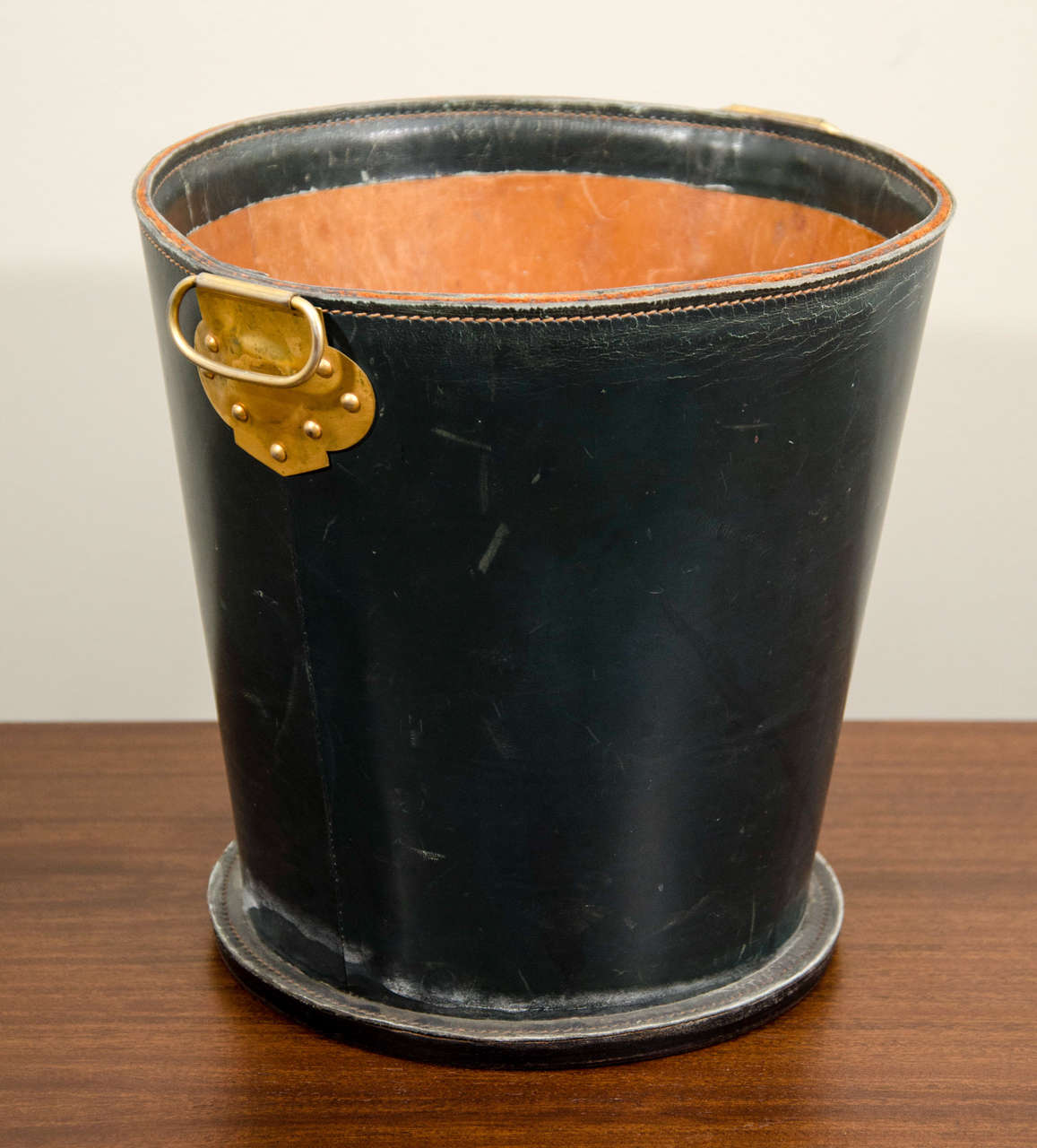 Elegant French leather waste paper basket with decorative brass handle.