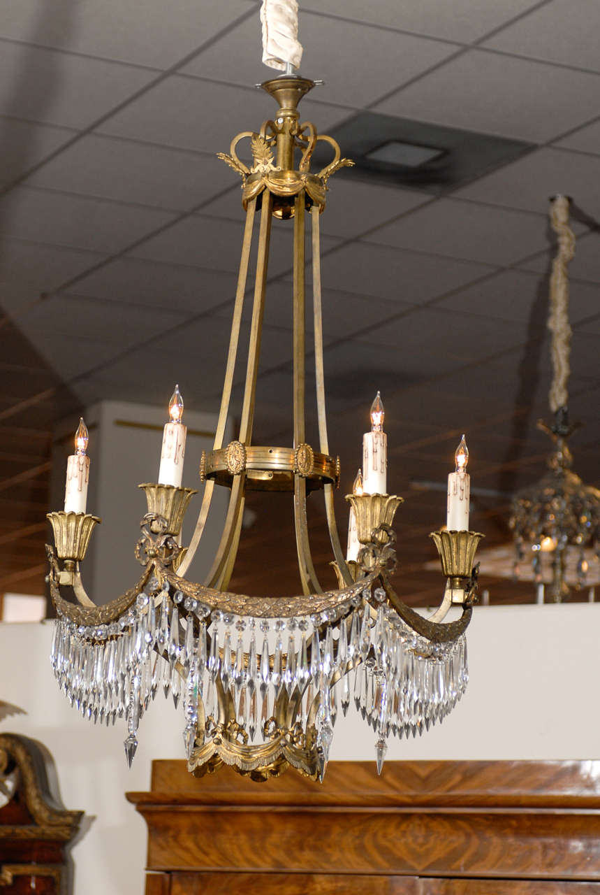 French chandelier in the neoclassical form with six lights, bronze dore frame with garland detail and crystal pendents draping below. 

William Word Fine Antiques: Atlanta's source for antique interiors since 1956.