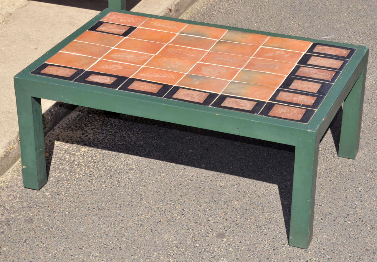 Two 1960s coffee tables by Roger Capron, with base in green patina wood and top surface clad in ceramic tiles with the imprint of leaves.