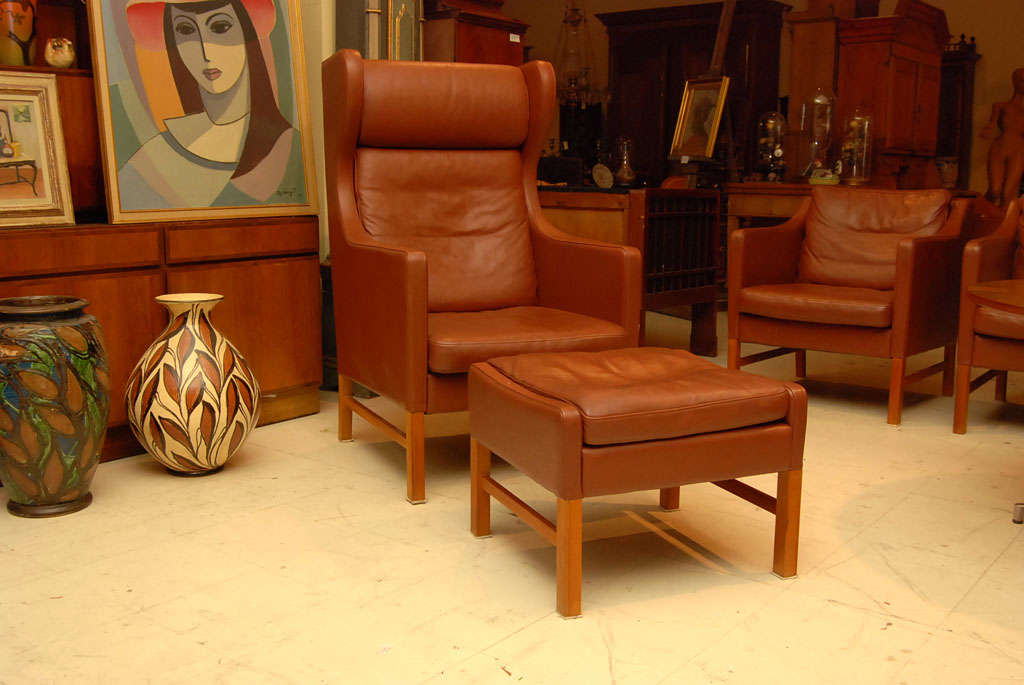 Handsome and comfortable wing back armchair, Danish modern, Borge Mogensen-style, with matching stool in a rich brown leather