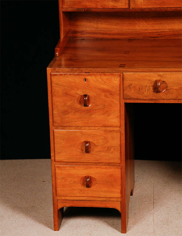 A Walnut Cotswold School Arts and Crafts Kneelhole desk.
Attributed to Peter Waals.
The upper section with two central doors flanked by drawers, the lower half with central drawer and six further drawers arranged around a knee hole, on shaped