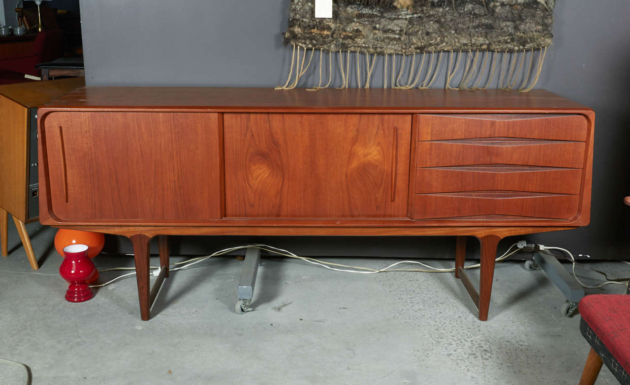 Vintage 1950s Teak Sideboard 

This Danish sideboard is in like new condition and has an unusual trapezoidal shape. Four Drawers, two sliding doors with adjustable shelves. Ready for pick up, delivery, or shipping.