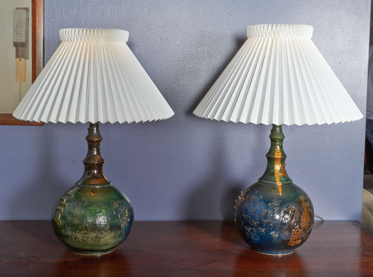 Vintage 1960s Keramic Table Lamps by Bjorn Wiinblad

This pair of Ceramic Lamps are in like new condition. The lamp is hand molded with random shapes carved into the clay, with gold leafing also placed randomly. One lamp is also more green than