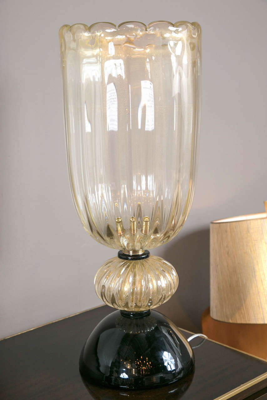 A pair of standing Murano, hand-blown glass torcheres with gold flecks in the clear glass and black glass bases.