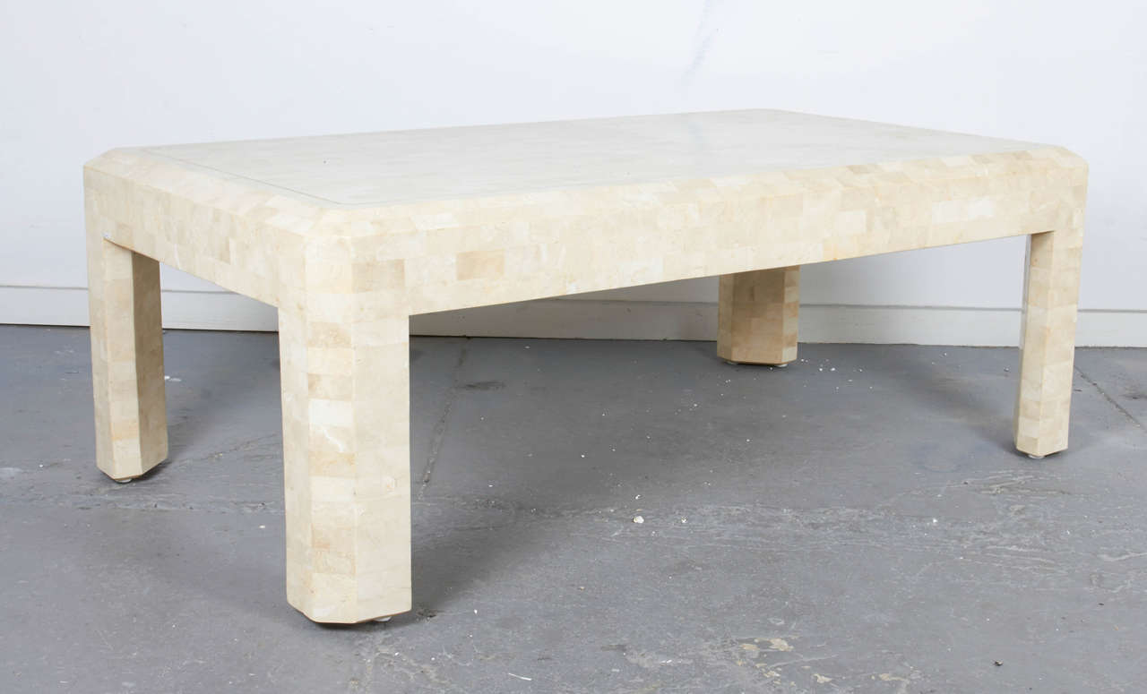 Tessellated coral stone coffee table with brass inlay detail.