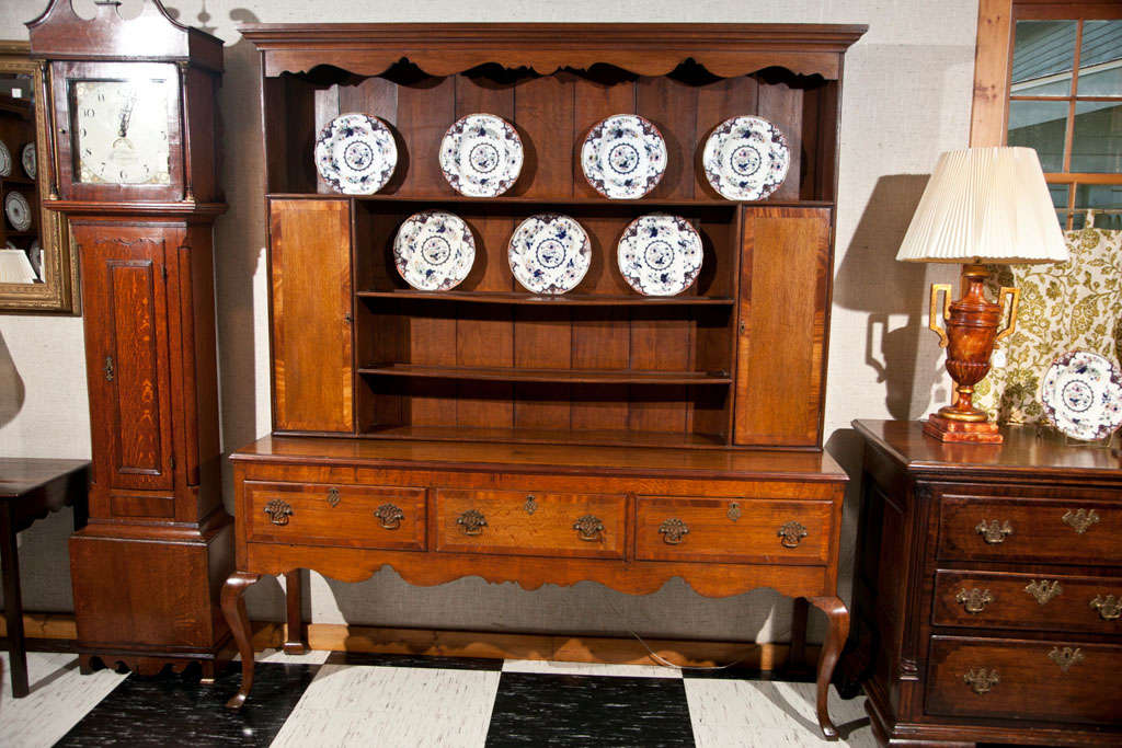 This Welsh dresser in oak with side cabinets, three drawers and cabriole legs has a rich, honey color and its proportions are perfect. The scalloped apron and mahogany crossbanding on the doors, serving surface and drawer fronts indicate that this