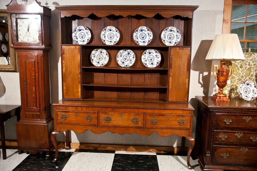 Cette commode galloise en chêne avec des meubles latéraux, trois tiroirs et des pieds cabriole a une couleur riche et miel et ses proportions sont parfaites. Le tablier festonné et les bandes transversales en acajou sur les portes, la surface de