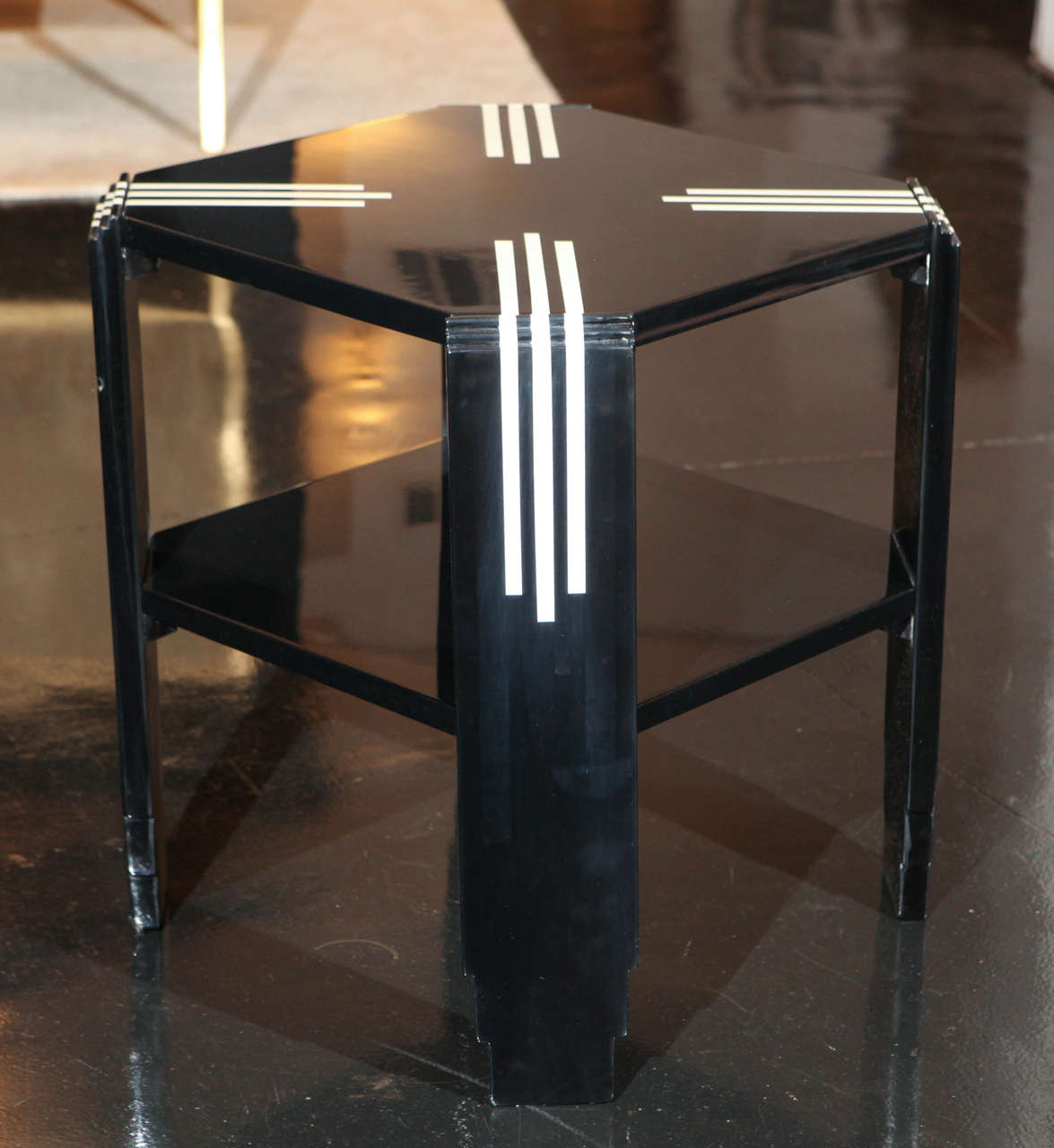 Art Deco-Modernist side table in black lacquer with ivory lacquer linear detailing along legs and top. 2-tier octagonal shape with stepped details on legs.
