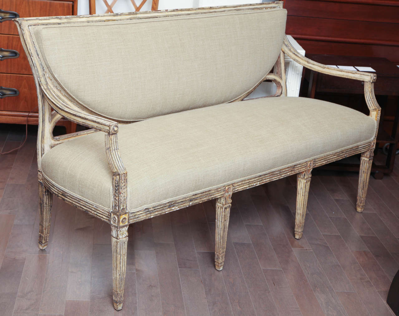 Carved 19th century continental settee with original painted finish and new linen upholstery