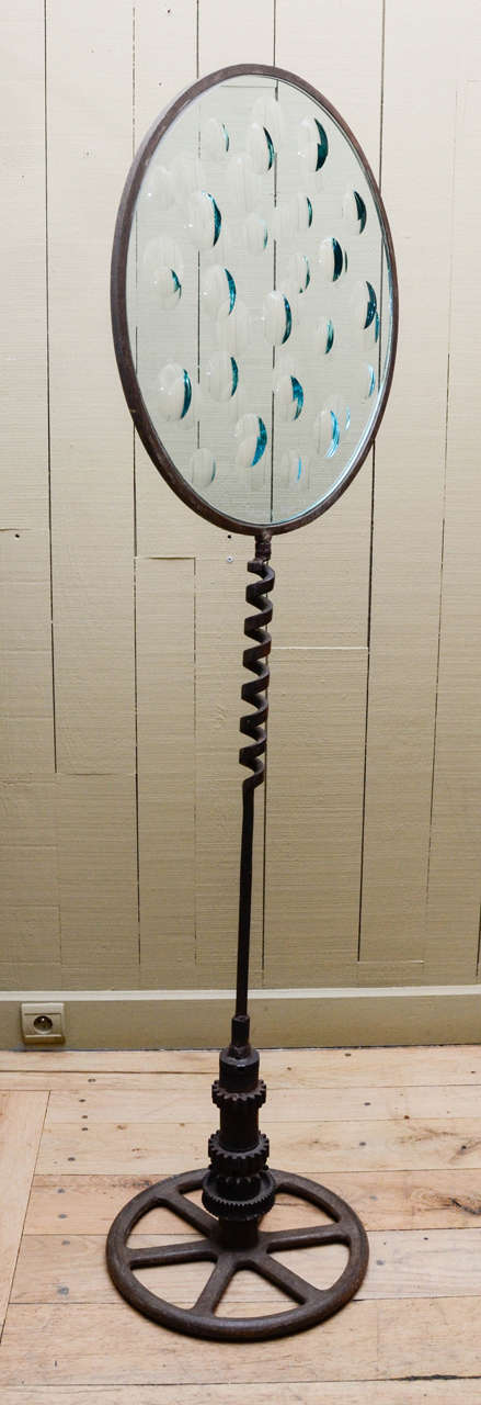 This piece is dated and signed by the Mexican artist in 1978.
The beautiful spiral stem is quite rare in his creations. The base has a very Rustic surface and is all made of reclaim iron parts. 
The glass disc is cut, to create some prism effects.