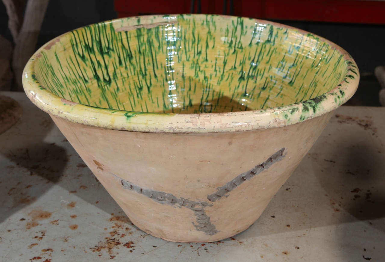 Late 19th century French pottery dough bowl with green glaze and tapered form. Stapled Repair