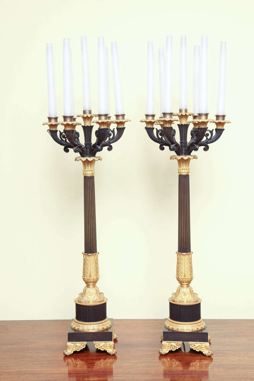 Pair of large Regency period finely cast ormolu and patinated bronze seven-light columnar candelabra, having six scrolled cast bronze arms centering a single upright arm all with ormolu nozzles above reeded columns on square base with ormolu flared