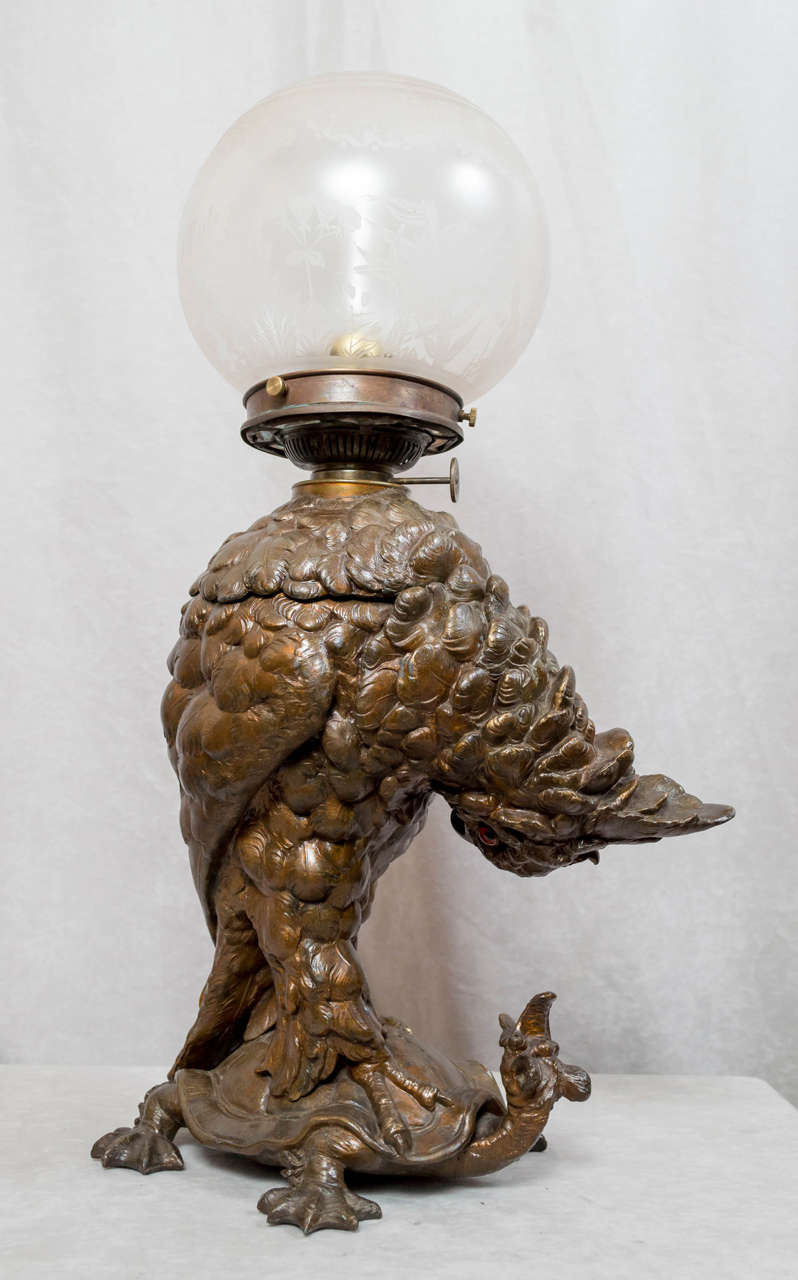 We love whimsy here, and this certainly fits that category. This well cast figural lamp has a beautiful original warm brown patina. The shade is an original period deep etched ball. The lamp has been fitted for electricity, and is fully working. The