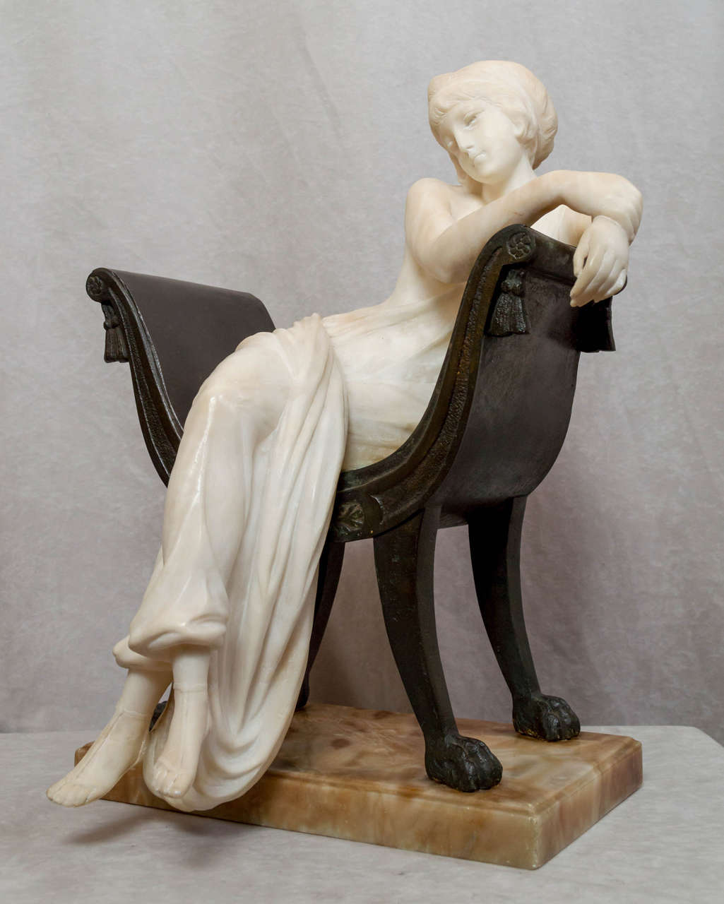 This lovely young girl seated in a chair is a fine example of the work of Emilio Fiaschi. He was Italian b.1858-d.1941. Known mostly for his alabaster carvings, this is a nice example of his using three mediums, alabaster and bronze and marble. The