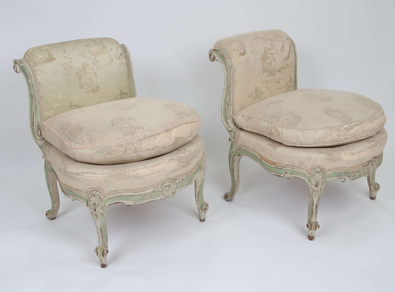 Pair of French Louis XV style low chairs retaining contemporary silk covering, circa 1850. The old material covered with conservation netting which can be removed if desired.