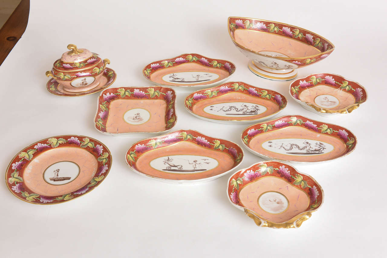 Decorated with the story of cupid, hand-painted in various pursuits surrounded with peach marbleized panels and iron red foliate borders, the underside with explanatory script. Comprising two clam-shaped dishes, one lozenge shaped tazza, 
four