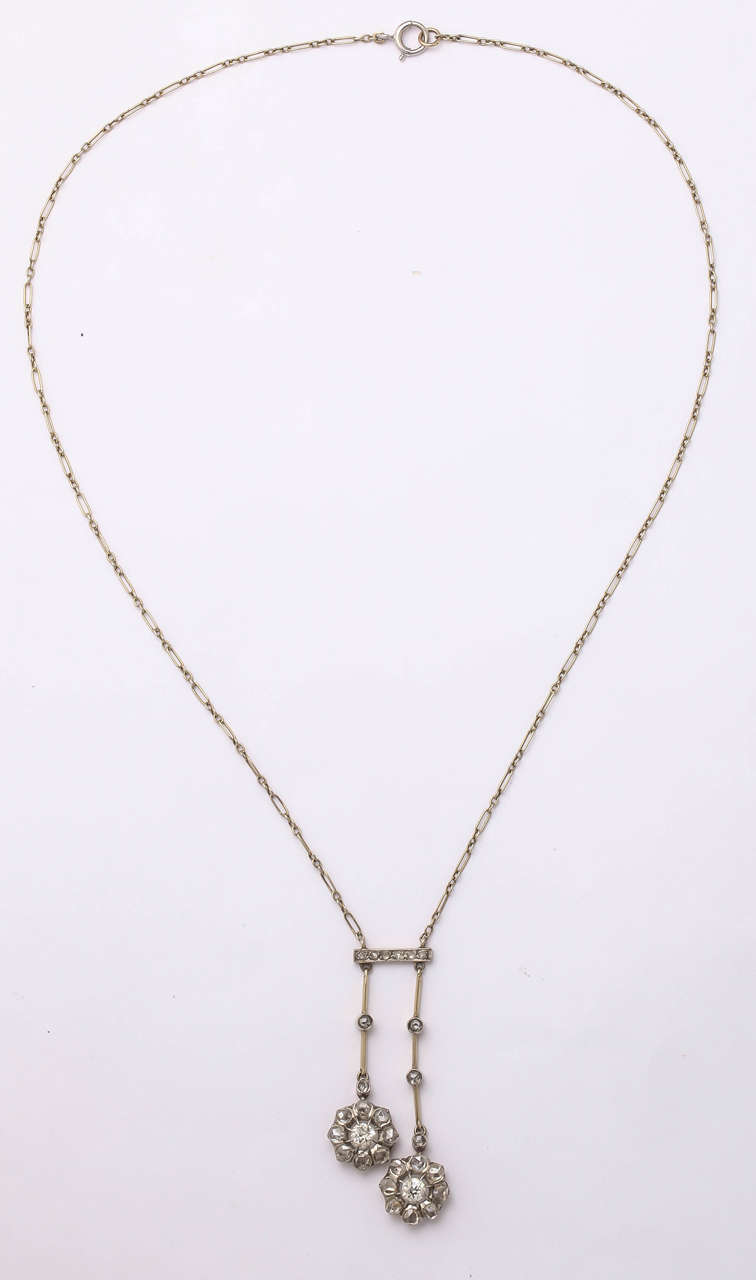 A stunning original Art Deco three-carat of cushion/european diamonds set in a neglige of two floral drops with smaller diamonds along the chain and bar set in platinum along a platinum and linked chain,
circa 1920.