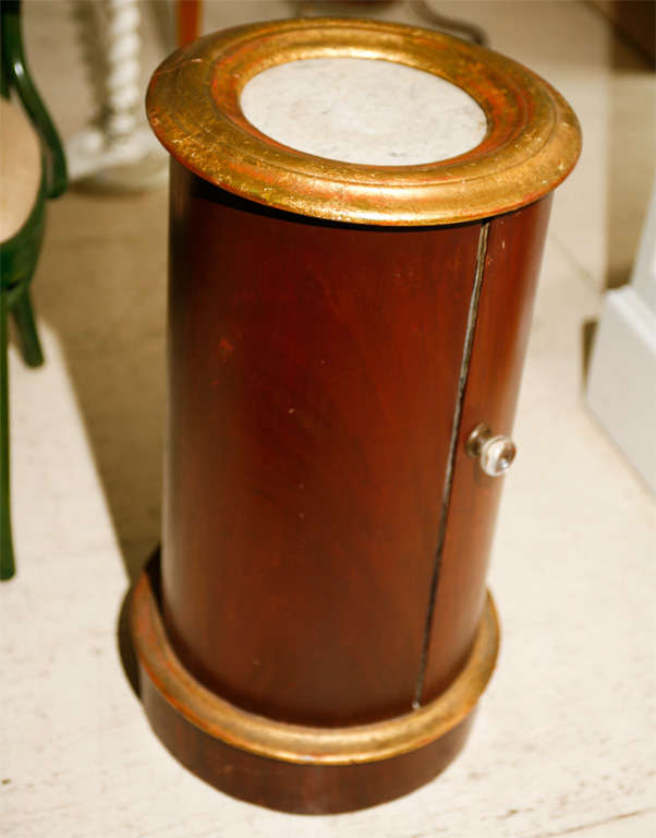 Mahogany and gilt edged pot table with white marble top.  White painted interior with one shelf.