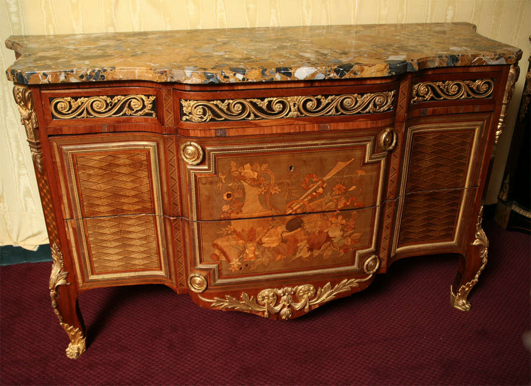 A very fine and impressive French 19 century Louis XVI style ormolu mounted marquetry inlaid marble-top commode.