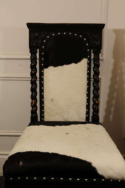 Pair of Black, Carved Chairs upholstered in Cow Hide In Excellent Condition For Sale In Toronto, ON