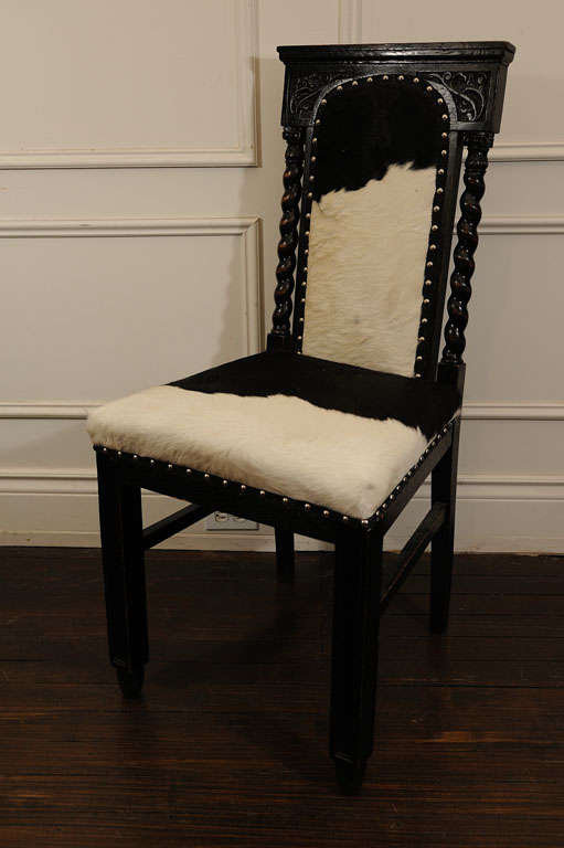 20th Century Pair of Black, Carved Chairs upholstered in Cow Hide For Sale