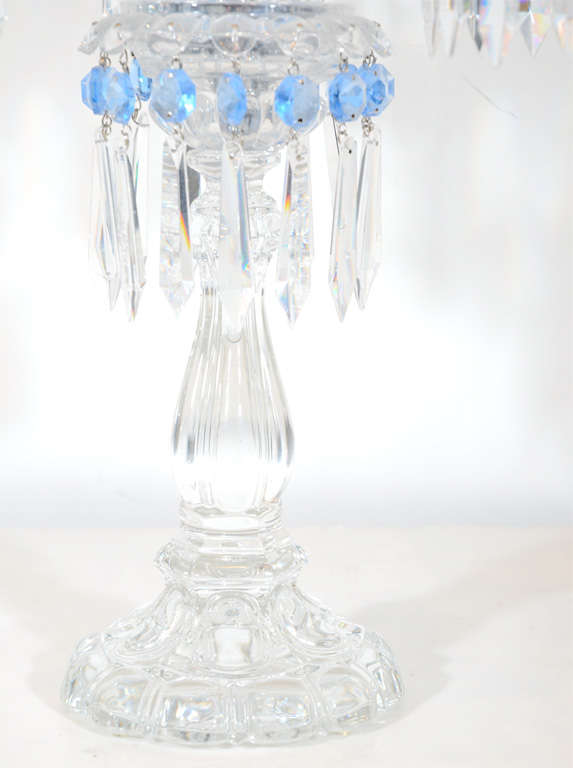 This stunning pair of Girandoles feature fine cut crystal pendants and pale blue cut crystal details. These Girandoles feature removeable hurricane shades with fine etched detailing. They are signed Baccarat on the bottom of each as well.
