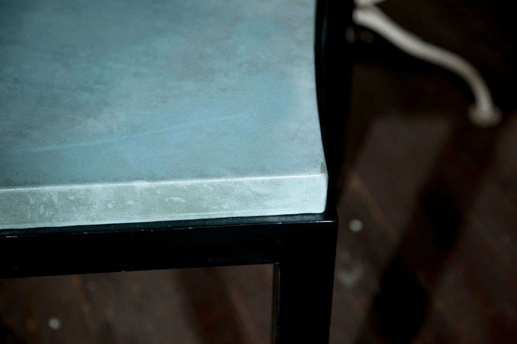 Table noire incurvée de style Parsons avec un magnifique plateau en cuir bleu.