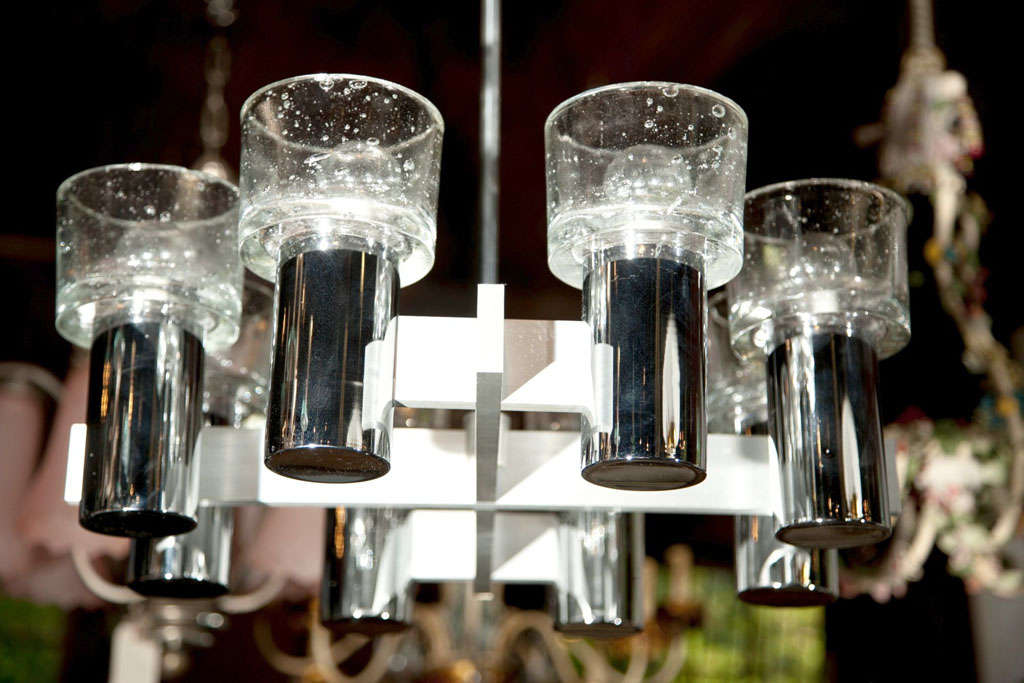 Stunning chrome and brushed steel and glass eight-arm chandelier. Each bulb is surrounded by a bubble glass cylindrical shade.