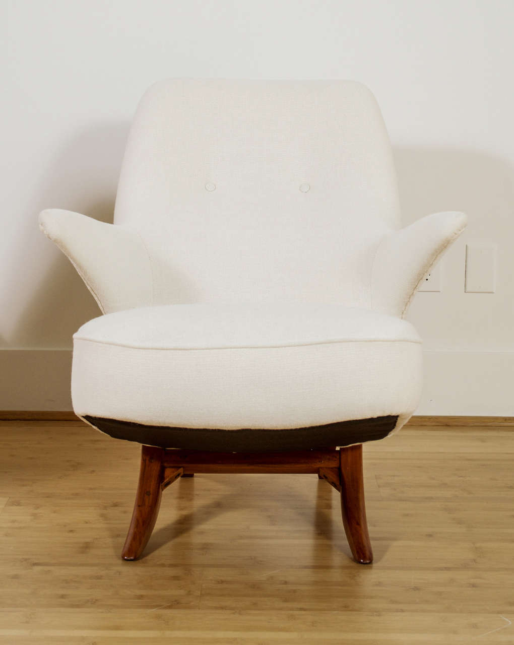 A Penguin Lounge Chair by Theo Ruth for Artifort. A modular design comprised of two interlocking pieces - seat and back can separate. White upholstery, with two covered buttons and legs of mahogany.