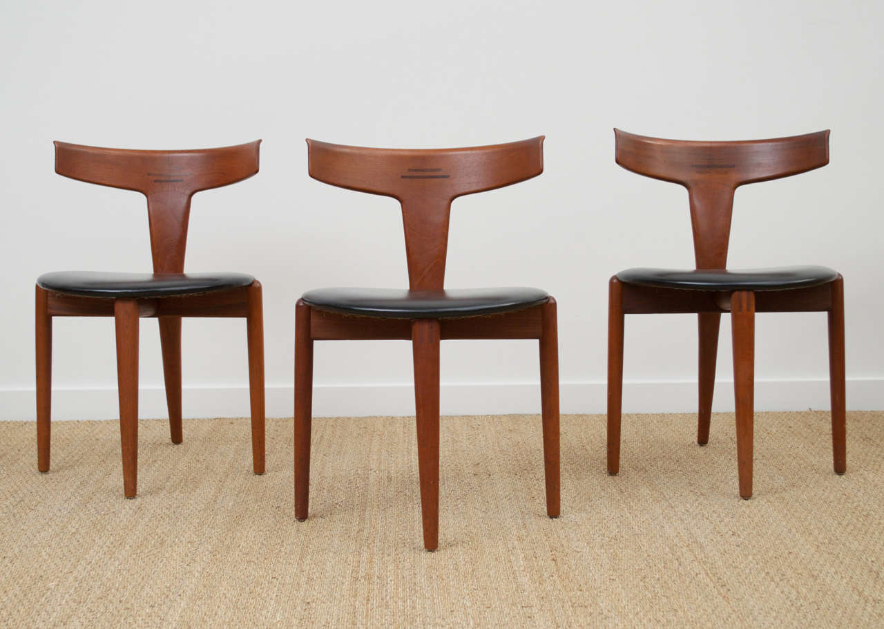 A set of 6 Teak dining chairs, with rosewood inlaid details, stamped for MM Moreddi Imports. Distinctive Leg pattern and unified rear leg and backrest.