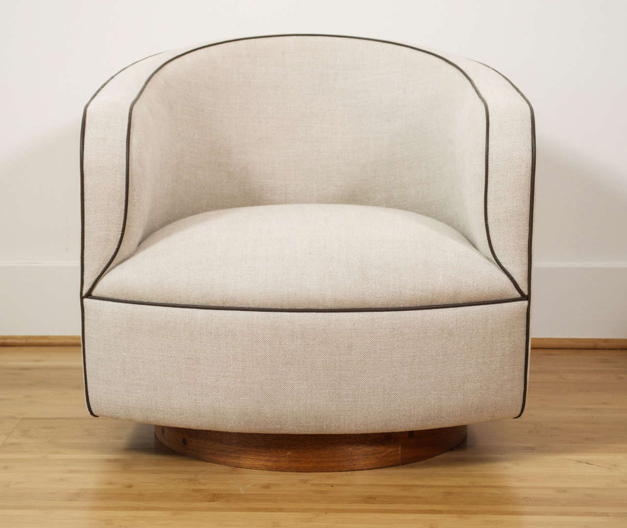 A Barrel shaped club chair by Milo Baughman for Thayer Coggin.
Features a low seat, and wide walnut base. Shown in beige linen, with contrasting brown piping. Base, upholstery, netting, and foaming newly restored. Pair available.