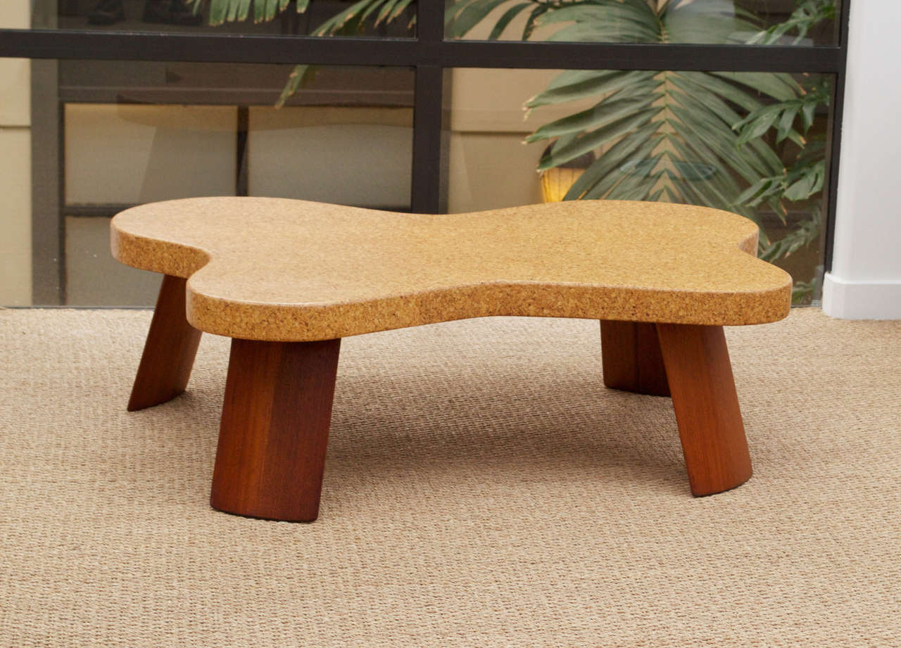 A rare, amoeba-shaped coffee table by Paul Frankl for The Johnson Furniture Company. Cork veneer top with solid mahogany legs. Marked as Model #5005.