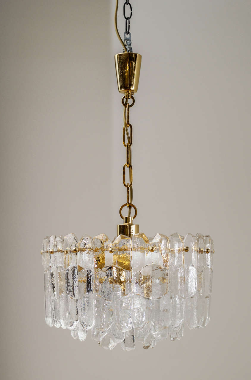 A Kalmar Vienna three-tiered pendant lamp. Fits eight lights, handblown glass tiles. Presumable gold-plated brass.