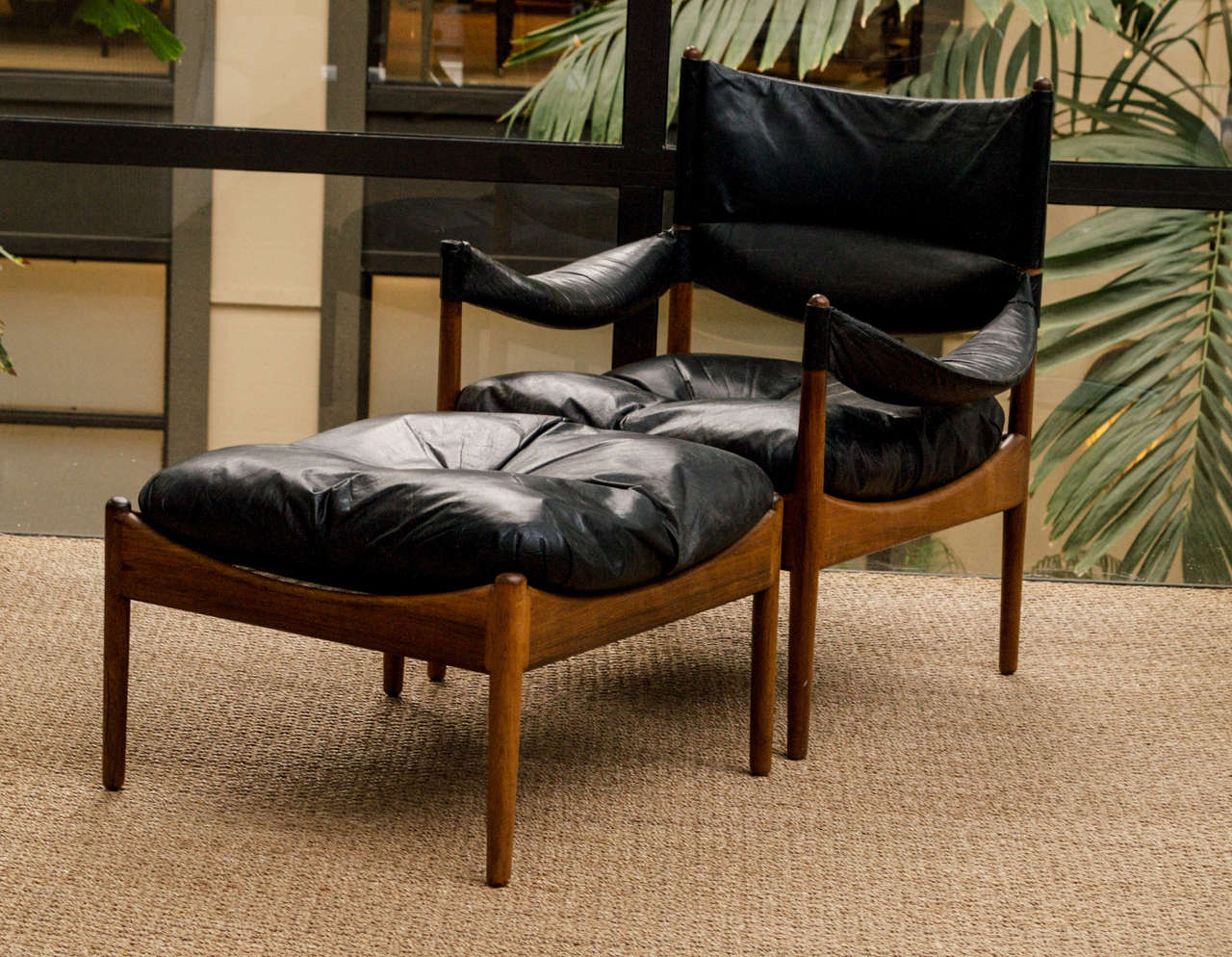 'Modus' easy chair with ottoman in Pale Rosewood. cushions of black leather. Designed in 1963. Produced by Søren Willadsen.  

Original Leather Upholstery with Age-appropriate wear.
