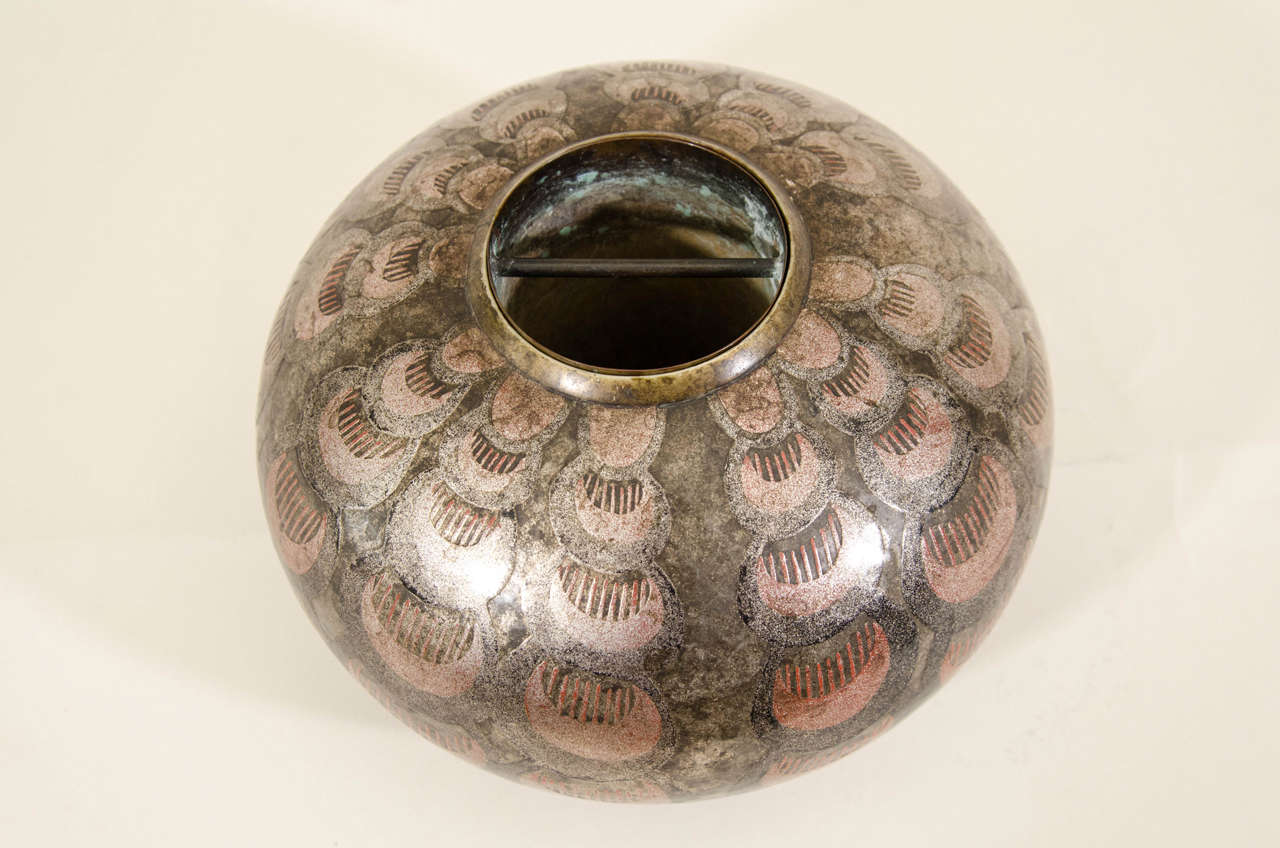 Hammered lead vase with a slightly flattened spherical body and bordered round opening rod. Copper cone liner. Decor of overlapping scales on two rows of black and red Aventurine gold lacquer.
Signed 