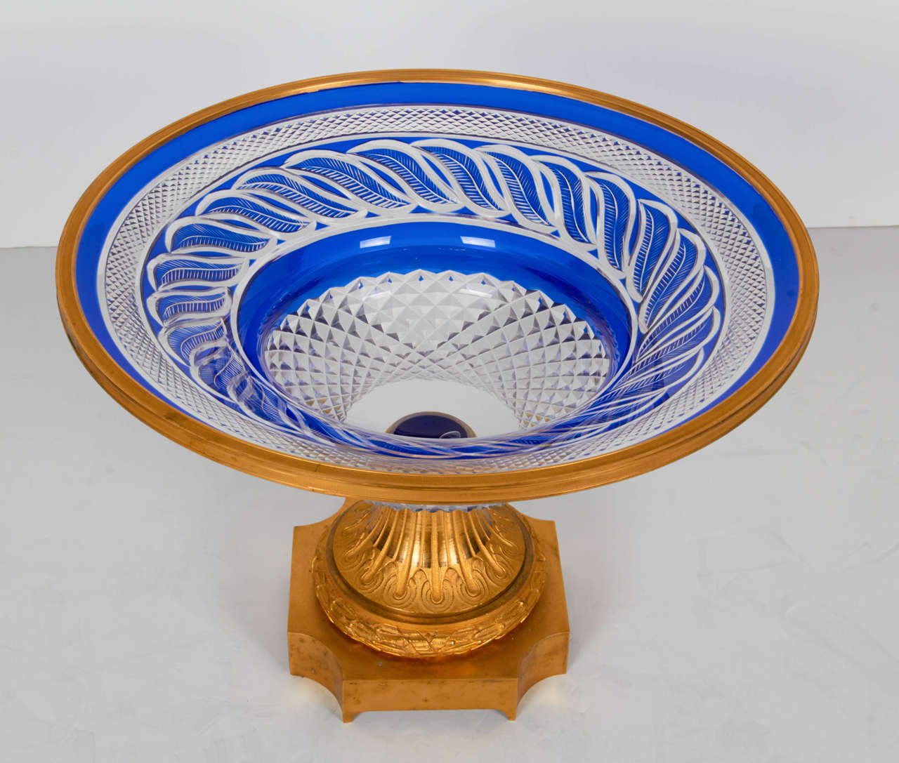 Un fenomenal centro de mesa ruso de cristal azul cobalto y bronce dorado con forma circular. Este exclusivo cristal azul cobalto tallado en transparente tiene un motivo de hojas azul cobalto de dos capas tallado a mano y rodeado de un excepcional