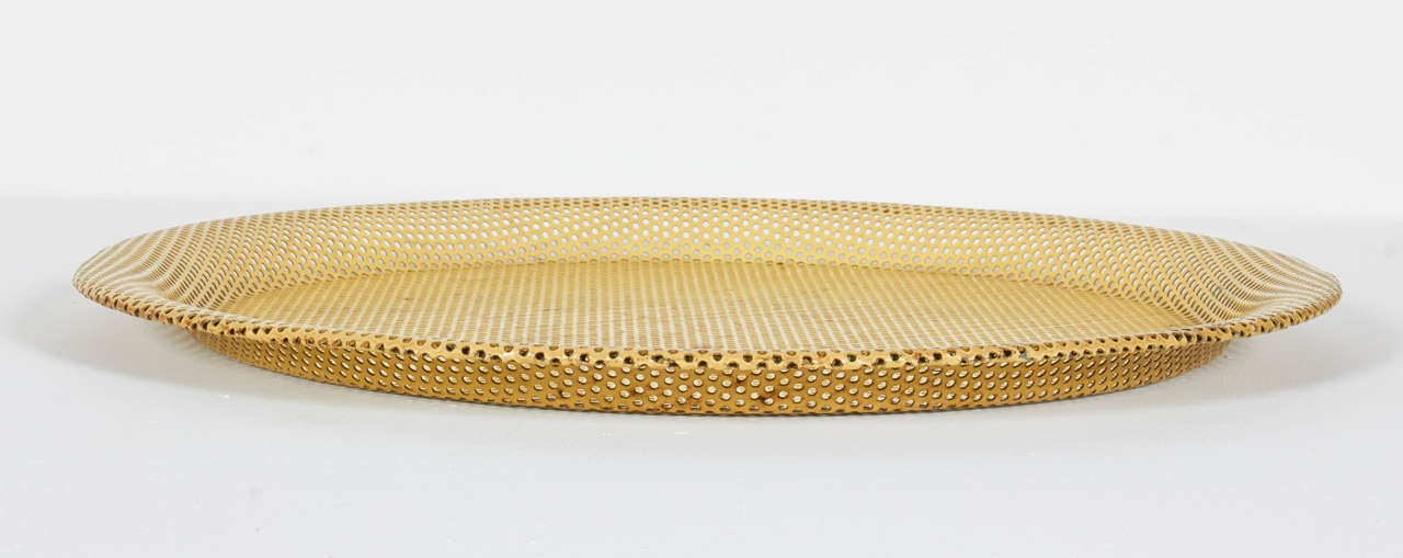 Perforated and enameled yellow metal tray.