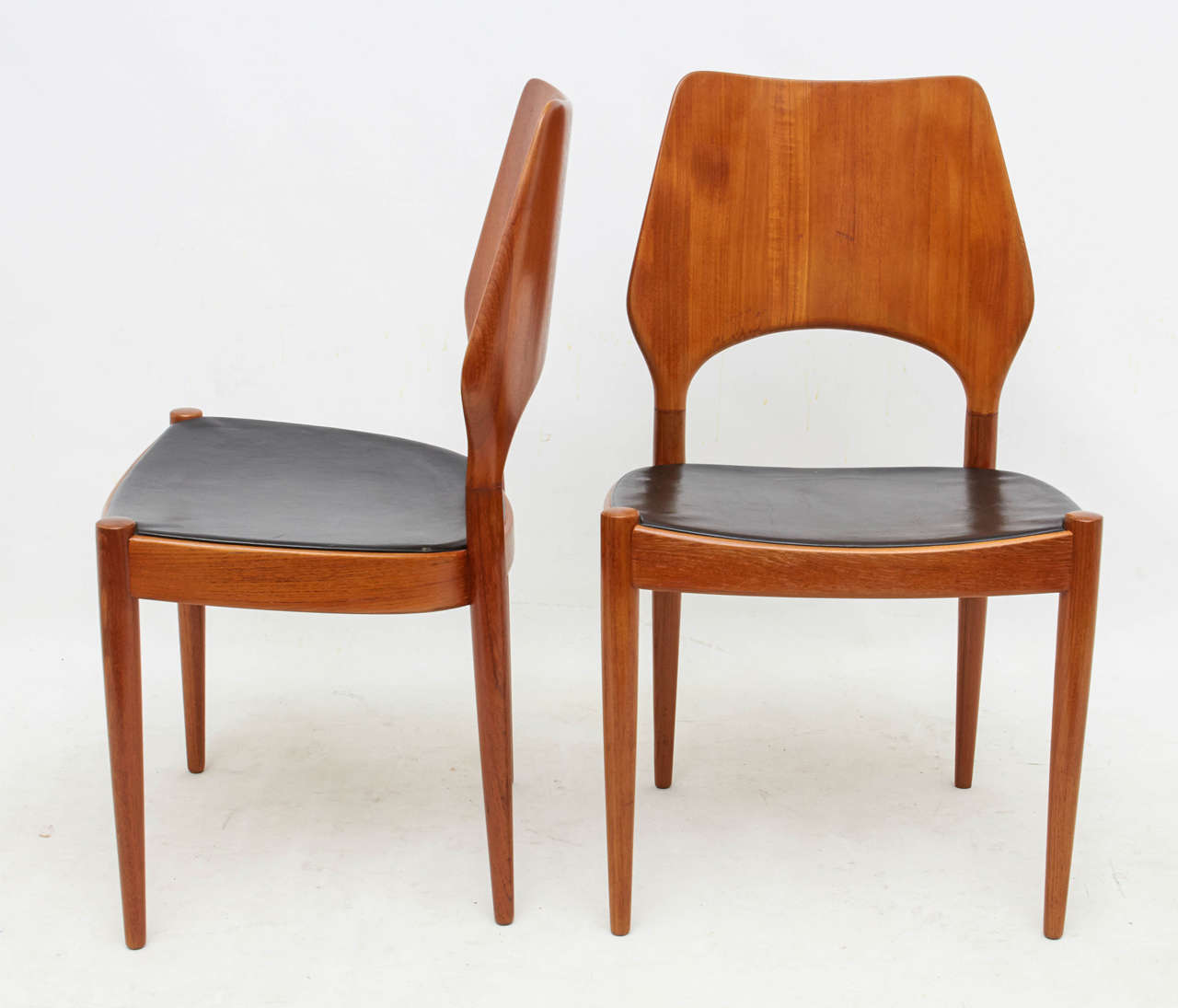Beautiful and rare set of six dining chairs with original leather seat covers. Remarkably sculpted solid teak backs and legs. Please contact for location.