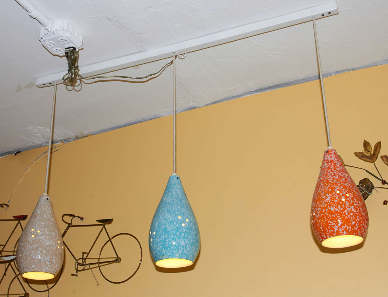 Set of three ceramic pendant lights finished in a colorful, speckled glaze. Each lamp has a graceful form and is pierced with small holes which add some sparkle. Very charming! Please contact for location. 